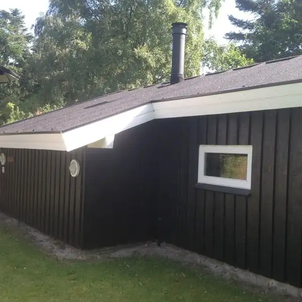 Sort sommerhus med nyt tagpaptag og hvid sternkant