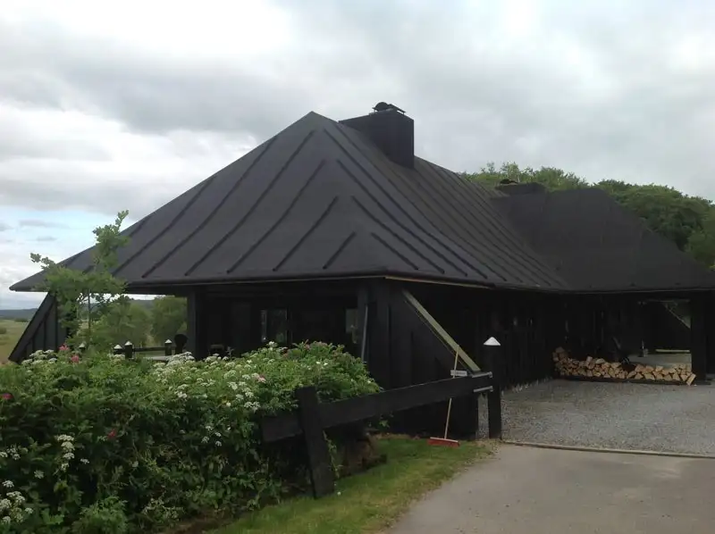 Sort hus med nyt tagpaptag og carport
