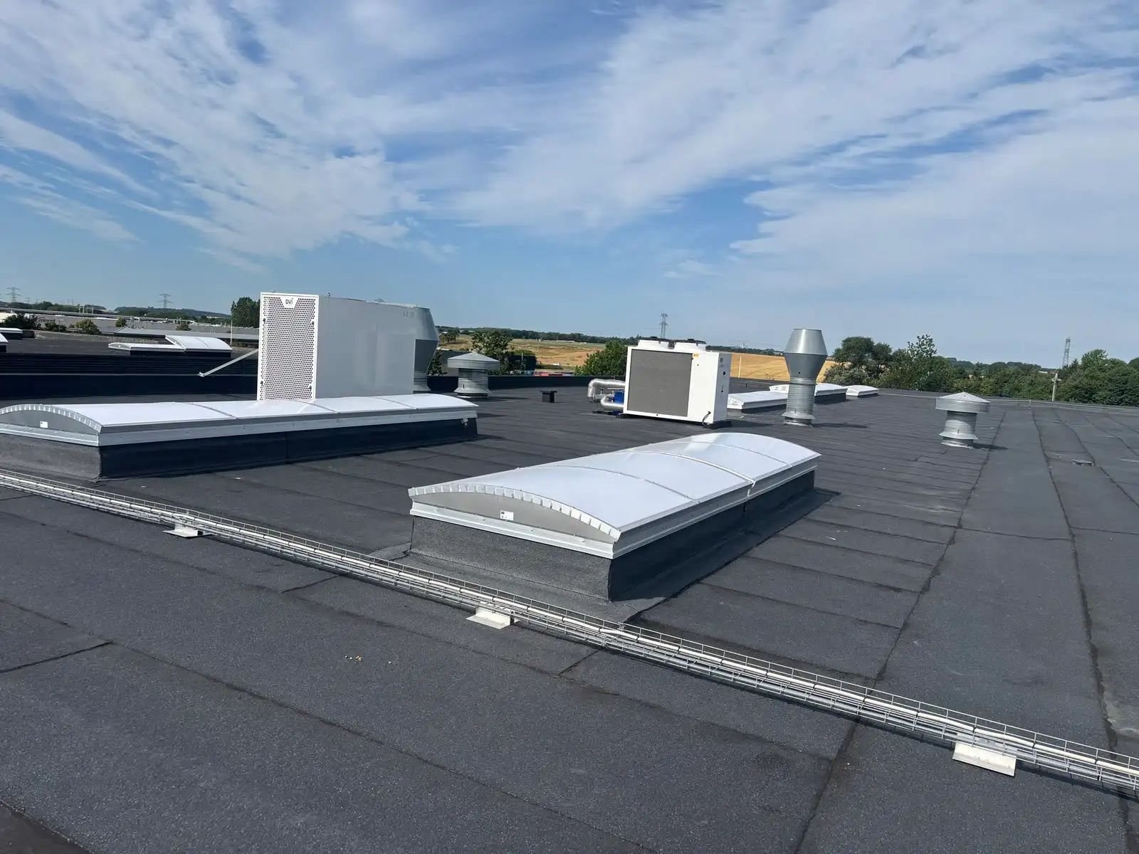 Stort fladt tagpaptag med ovenlys og ventilationsanlæg