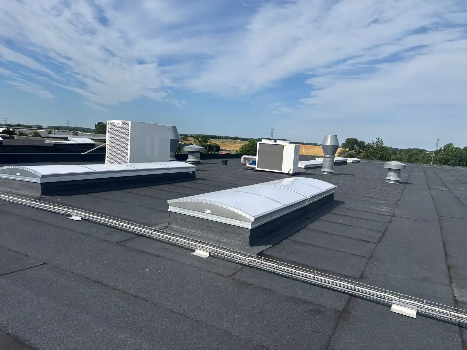 Stort fladt tagpaptag med ovenlys og ventilationsanlæg